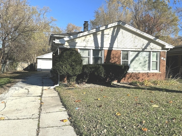 view of side of home featuring a lawn, a garage, and an outdoor structure