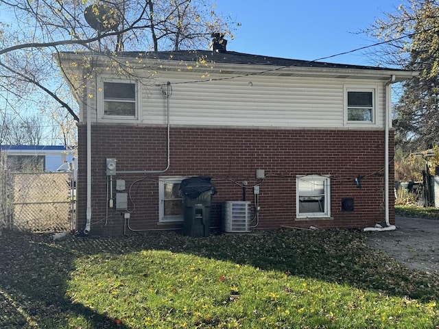 back of house featuring central AC and a yard