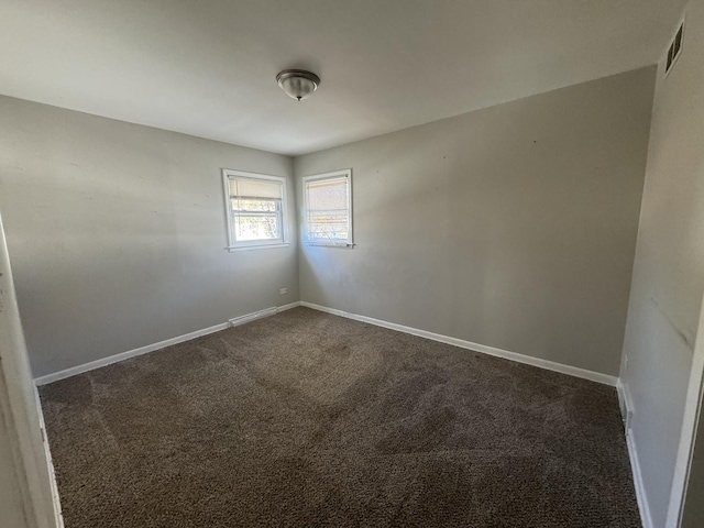 spare room with dark carpet