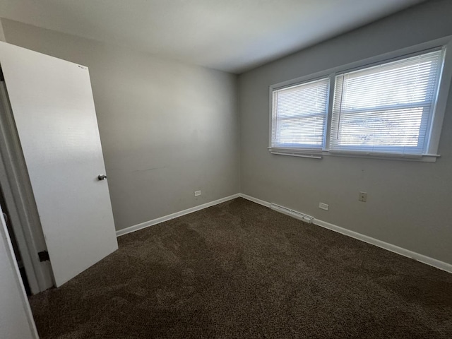 empty room featuring dark colored carpet