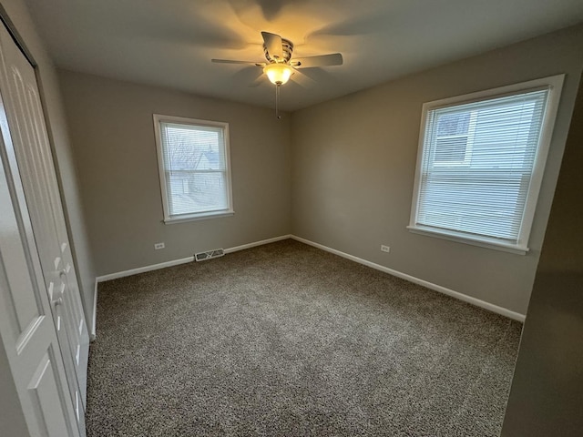 spare room featuring ceiling fan and carpet