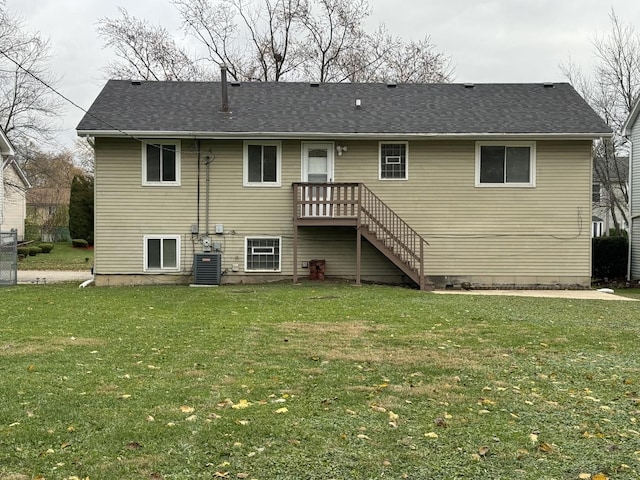 rear view of property featuring a yard and central air condition unit