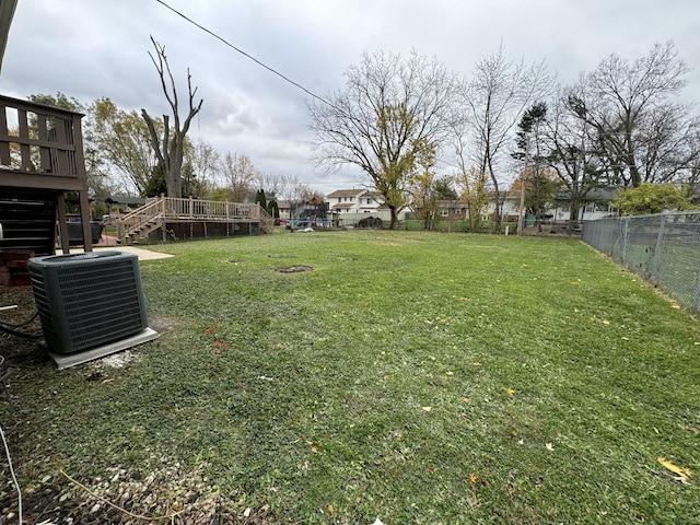 view of yard featuring cooling unit and a deck