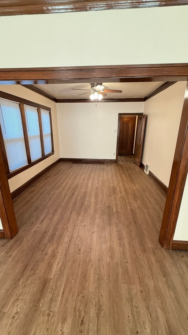 unfurnished living room with ceiling fan, ornamental molding, and hardwood / wood-style flooring