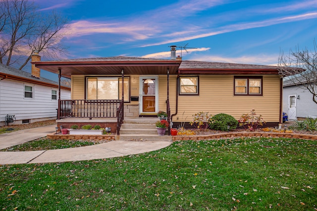 view of front of home with a porch and a yard