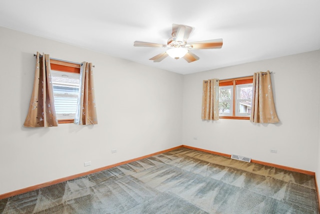 carpeted spare room with ceiling fan