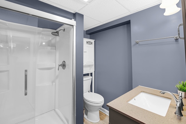 bathroom featuring a shower, hardwood / wood-style floors, toilet, a paneled ceiling, and vanity