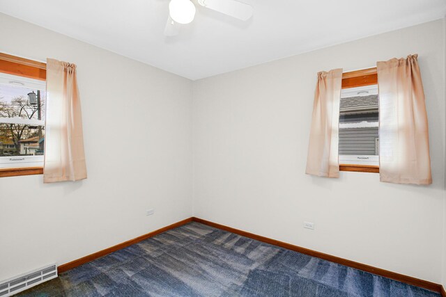 carpeted spare room featuring ceiling fan