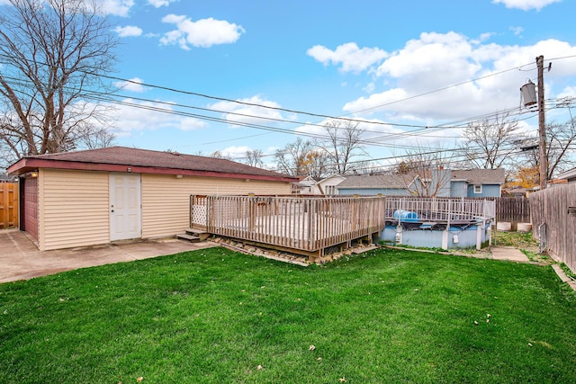 view of yard with a patio area, an outdoor structure, and a pool side deck