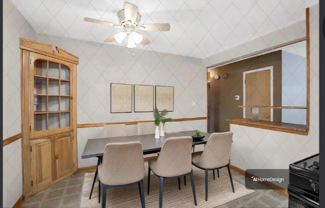 tiled dining space featuring tile walls and ceiling fan