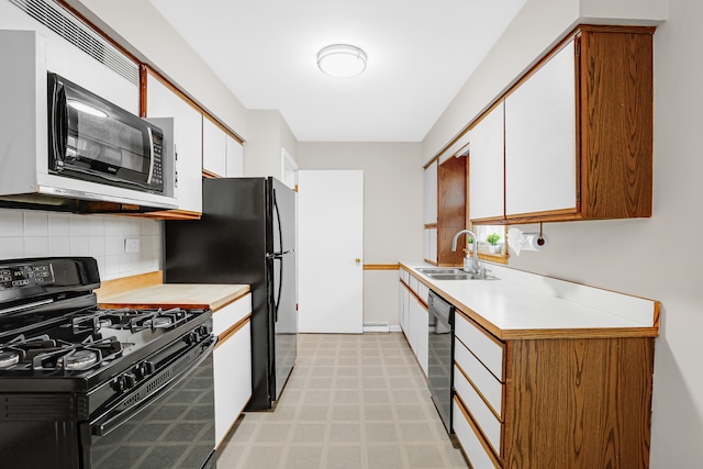 kitchen featuring black appliances, backsplash, white cabinetry, and sink