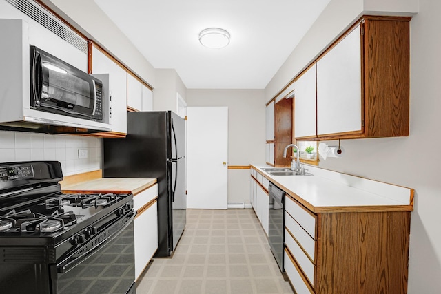 kitchen with sink, black appliances, white cabinets, and decorative backsplash