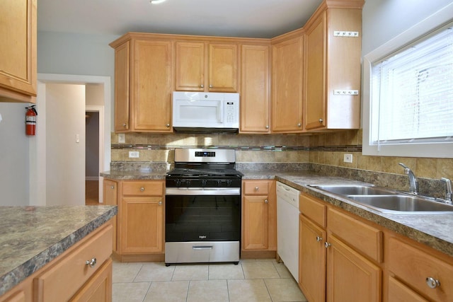 kitchen with backsplash, sink, light tile patterned floors, and white appliances