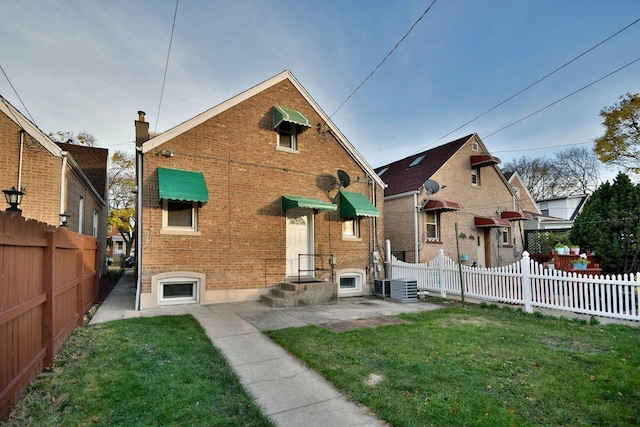 view of front of property featuring cooling unit and a front lawn