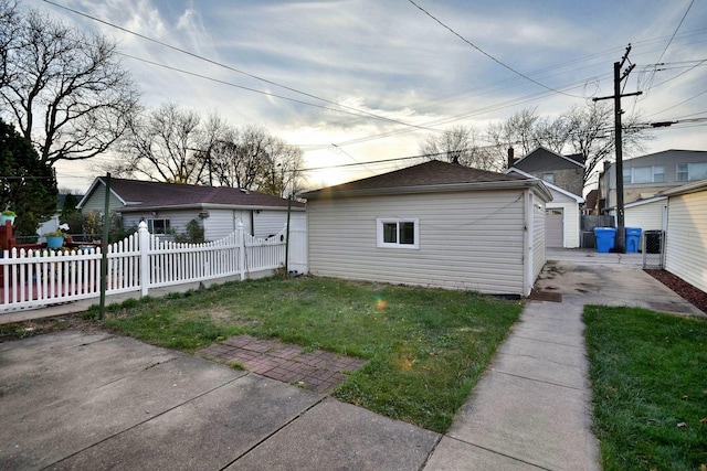 view of side of property featuring a garage, an outdoor structure, and a yard