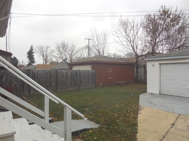 view of yard featuring a garage and an outbuilding