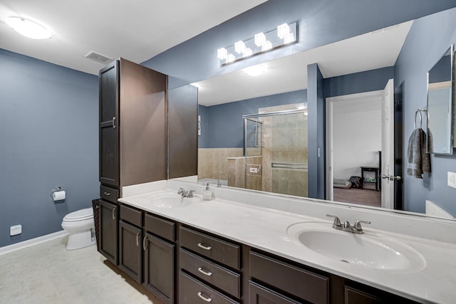bathroom featuring baseboards, a sink, toilet, and a shower stall