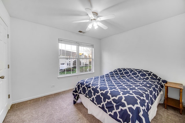 carpeted bedroom with baseboards, visible vents, and ceiling fan