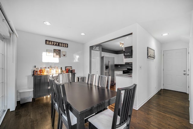 dining room with recessed lighting, baseboards, dark wood-style floors, and a bar