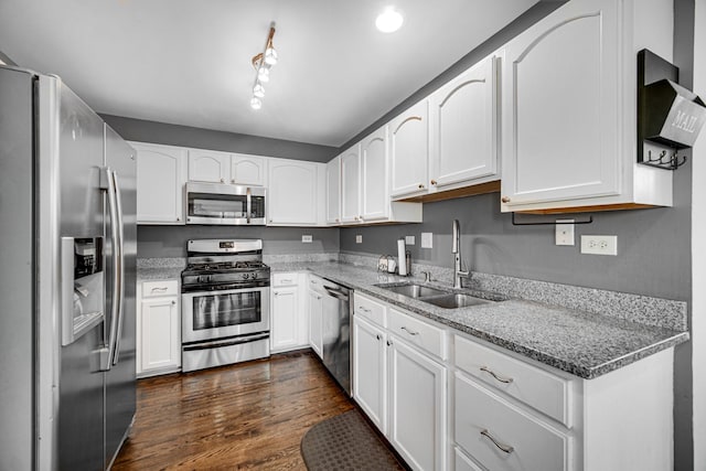 kitchen featuring a sink, appliances with stainless steel finishes, white cabinets, and light stone countertops