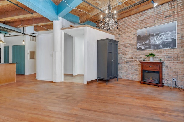 unfurnished living room featuring beamed ceiling, wood-type flooring, a towering ceiling, and wooden ceiling