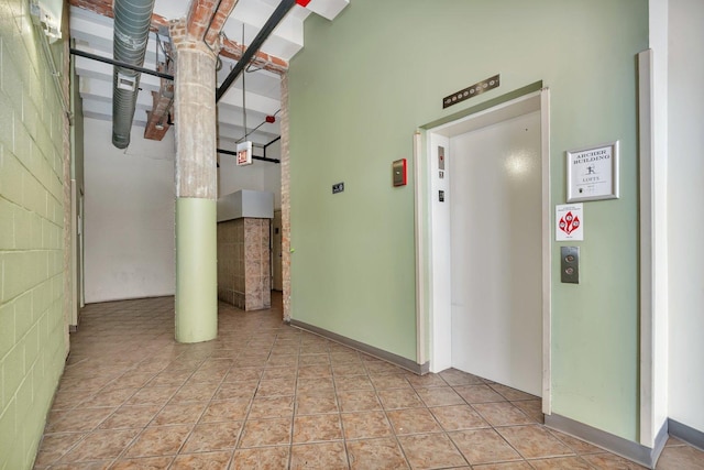 corridor featuring a high ceiling and elevator