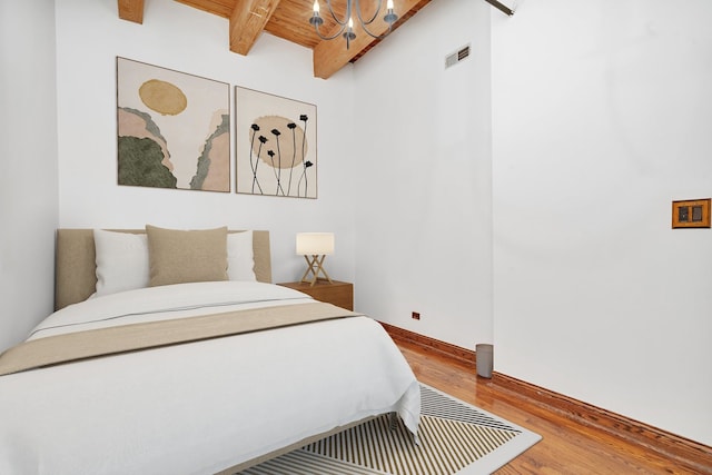 bedroom with beam ceiling, wood ceiling, and wood-type flooring