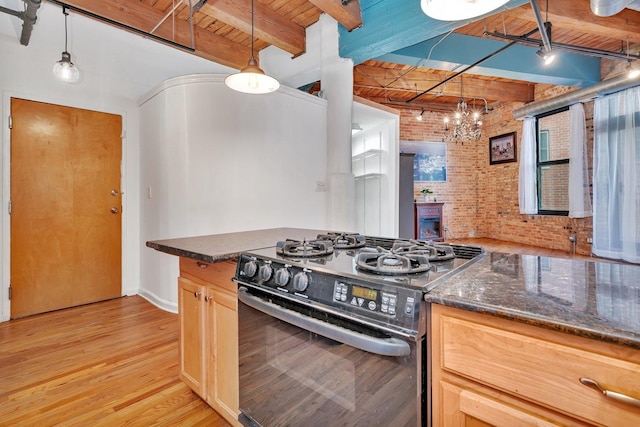 kitchen featuring brick wall, gas stove, pendant lighting, light hardwood / wood-style flooring, and wooden ceiling