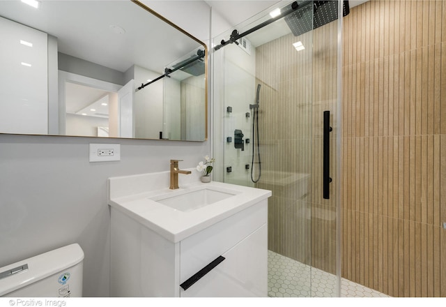 bathroom featuring vanity, toilet, and a shower with shower door