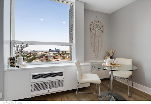 dining room with dark hardwood / wood-style flooring and an AC wall unit