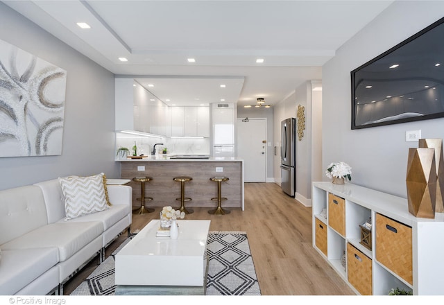 living room with sink and light hardwood / wood-style flooring