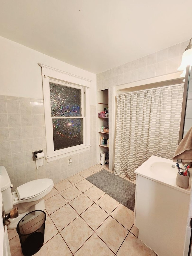 bathroom with vanity, tile patterned floors, built in shelves, toilet, and tile walls