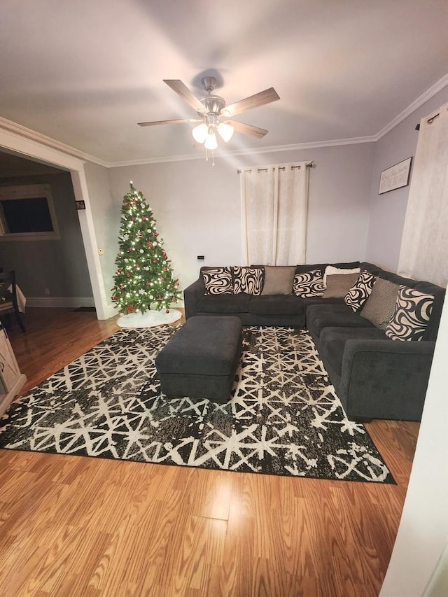 living room featuring hardwood / wood-style flooring, ceiling fan, and ornamental molding