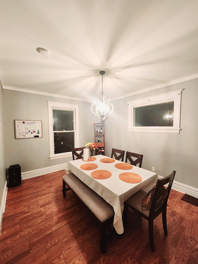 dining area with dark hardwood / wood-style flooring, ornamental molding, and a chandelier