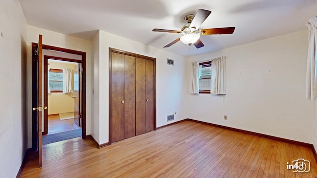 unfurnished bedroom featuring light hardwood / wood-style flooring, a closet, and ceiling fan