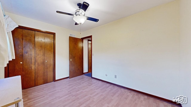 unfurnished bedroom featuring ceiling fan, a closet, and light hardwood / wood-style floors