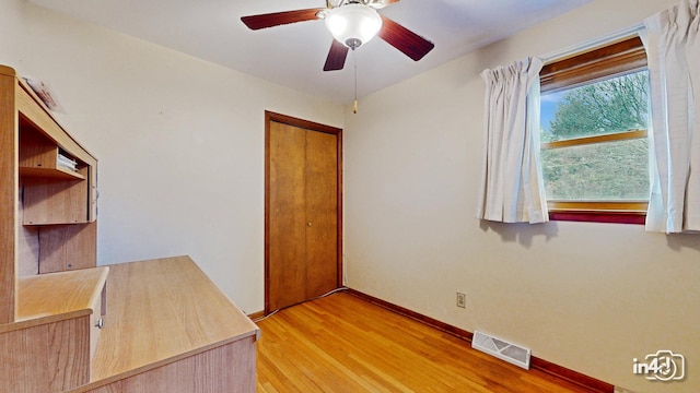 unfurnished office with ceiling fan and light wood-type flooring