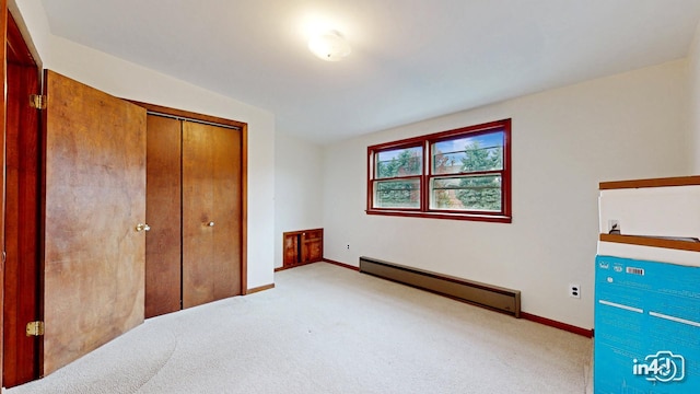 unfurnished bedroom with a closet, vaulted ceiling, light carpet, and a baseboard radiator