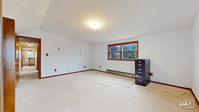 empty room featuring light carpet, a baseboard radiator, and lofted ceiling