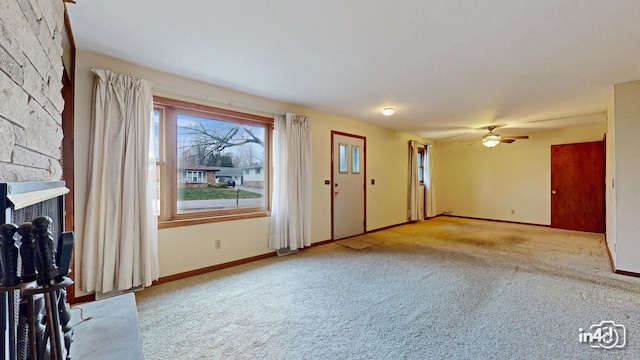 unfurnished living room featuring ceiling fan and light carpet