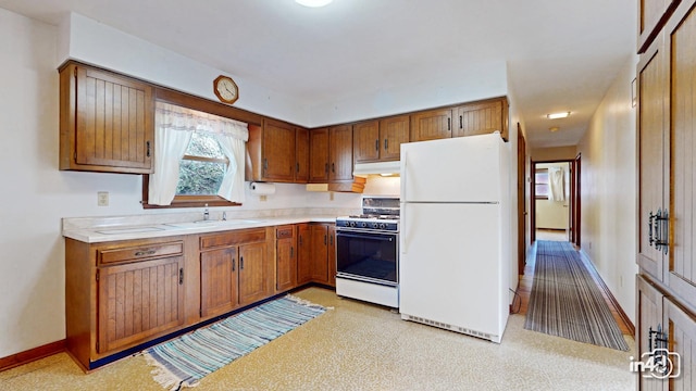 kitchen with light carpet, sink, and white appliances