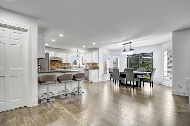 dining room featuring dark wood-style floors, baseboards, a chandelier, and recessed lighting