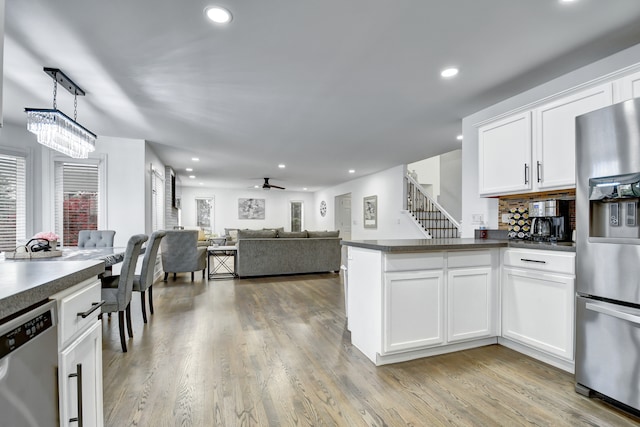 kitchen with stainless steel appliances, dark countertops, recessed lighting, light wood-style floors, and white cabinets