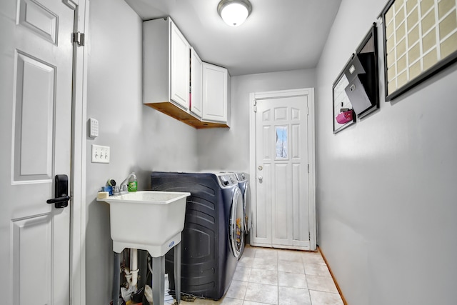 laundry room featuring cabinet space, light tile patterned floors, baseboards, and washer and dryer