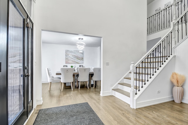 foyer entrance featuring stairs, baseboards, and wood finished floors