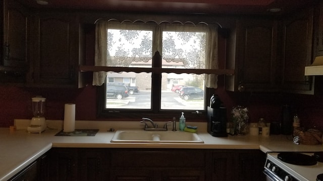 kitchen featuring stainless steel range with electric stovetop, dark brown cabinetry, sink, and extractor fan