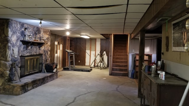 basement with a paneled ceiling and a fireplace