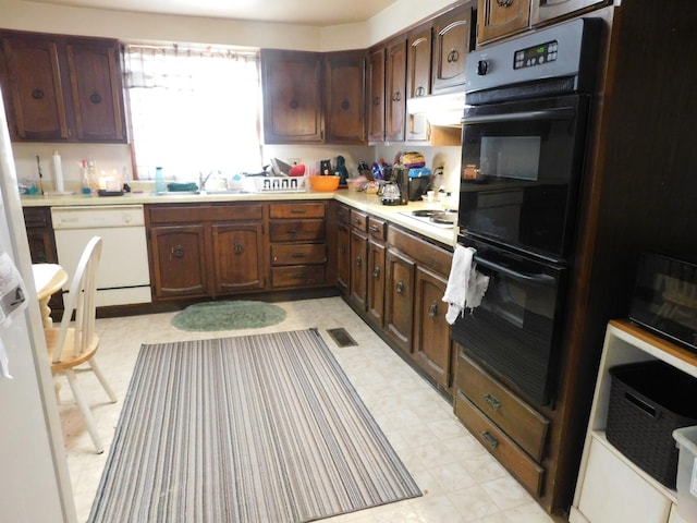 kitchen with dark brown cabinetry, sink, and white appliances