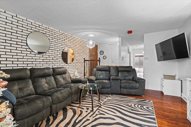 living room with dark wood-type flooring and brick wall