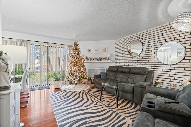 living room with hardwood / wood-style floors and brick wall